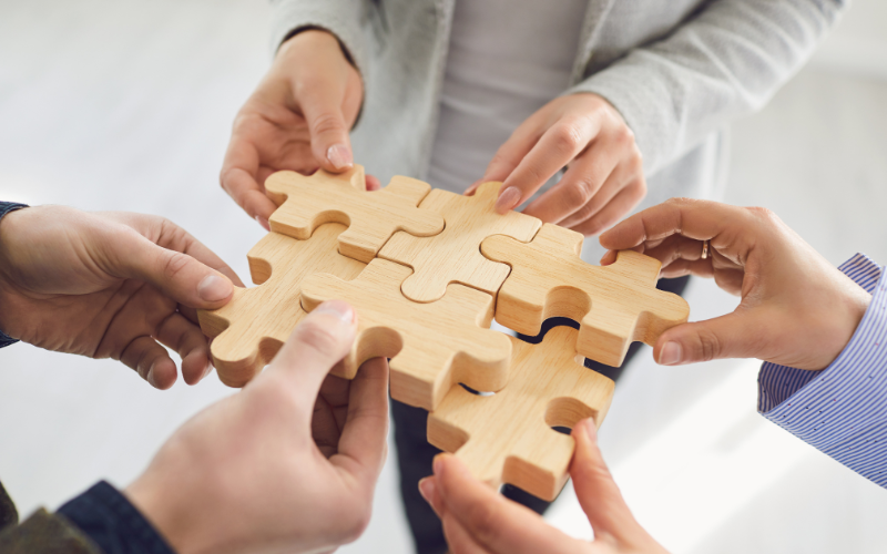 People piecing a jigsaw together