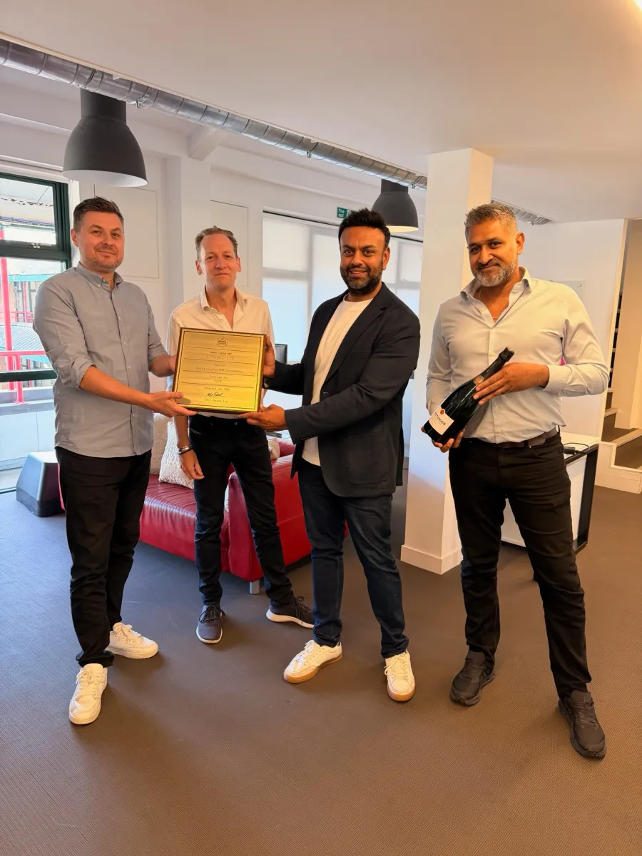Four members of Conosco's leadership team in the Chelsea office, holding the Assurix Trusted MSP plaque